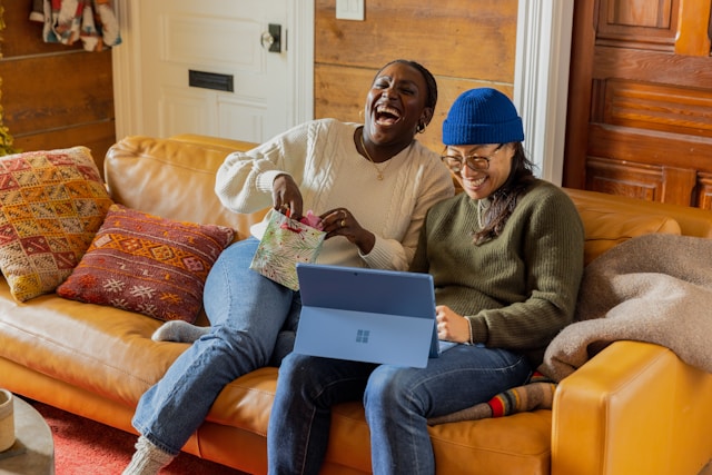 Happy clients on a sofa with a laptop